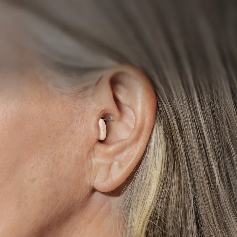 Close-up of an Atom Air hearing aid sitting inside a woman's ear