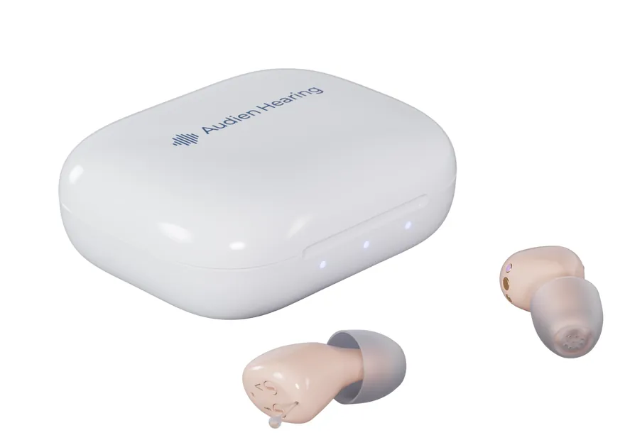Audien Atom Air hearing aids beside their white charging case